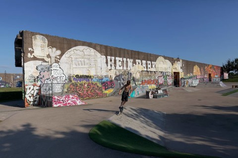 Rehinpark Duisburg, skate park with graffiti wall, boy jumping with stunt scooter, Duisburg, North