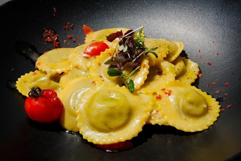Ravioli, Italian dumplings, filled, pasta served on a plate, primo piatto, 1st main course, cherry