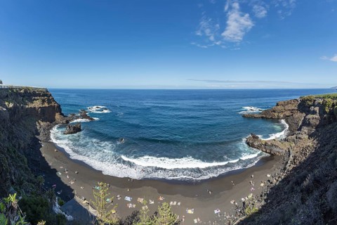 The lava beach lined with bathers, Playa del Bollulo, near Puerto de la Cruz, Tenerife, Canary