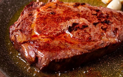 Fried steak, beef steak, rib eye steak, in a frying pan, top view, no people