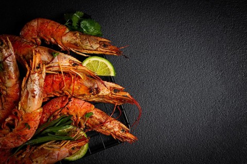 Langoustines, Australian, freshly frozen on ice, top view, lime and greens