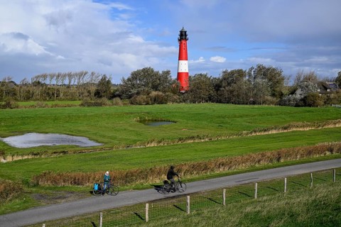 Cyclist in front of the lighthouse from 1906, island of Pellworm, Schleswig-Holstein Wadden Sea
