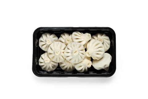 Freshly frozen, raw khinkali, in a black plastic container, top view, no people, Georgian cuisine