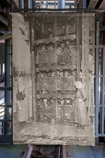 1920s old photograph showing coal miners in coal mining lift cage, elevator at Le Bois du Cazier