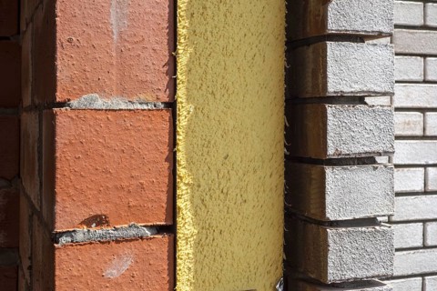 Close up of cavity wall insulation boards fitted in masonry cavities in newly built house used to