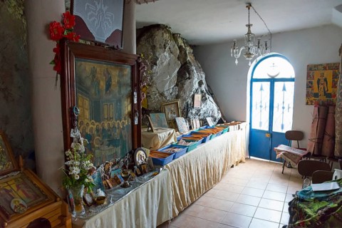 Room with religious pictures and icons on a long table next to a door, Rock Church of Smerna,