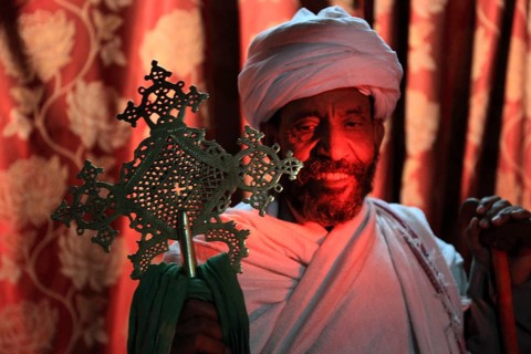 Rock churches of Lalibela, in the Church of the Cross, Bete Maskal, pilgrims, priest with cross,