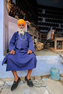 Man in traditional dress in front of a shoe shop, Bharatpur, Rajasthan, India, Asia