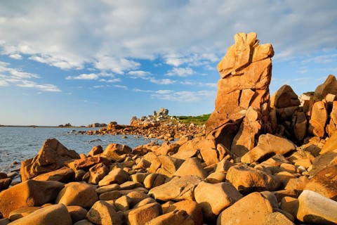 Striking orange-coloured rock formations in the evening light, on the coast of the English Channel
