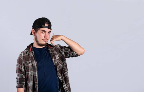 Man making phone gesture with his fingers, Hispanic young man making phone gesture and pointing to