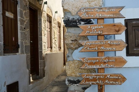 Alley with wooden signs and historic building, tourist atmosphere, Mandraki, Nisyros, Dodecanese,