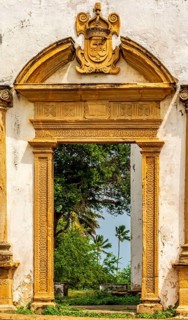 Baroque church portal overlooking tropical vegetation and ruins in the city of Olinda in