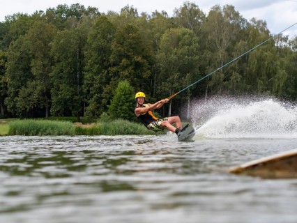 Sporty man with wakeboard, water sports, water skiing and wake park