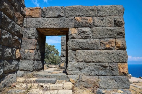 Ancient ruined wall with an archway in an arid landscape overlooking the sea, Palaiokastro, Ancient