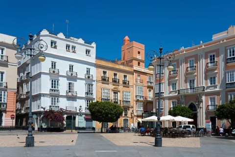 Urban square with colourful historic buildings and trees under a blue sky, Plaza de San Antonio,
