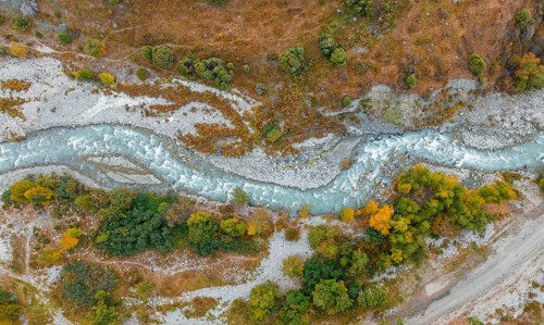 Aerial view, mountain stream Ala Archa flows through the Ala Archa valley, autumnal mountain