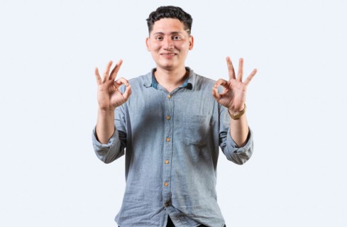 Interpreter person gesturing OK in sign language. Smiling young man gesturing APPROVED in sign