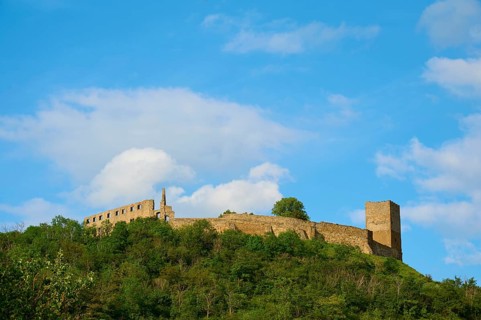 A castle ruin on a wooded hill under a blue sky with clouds, Gleichen Castle or Wanderslebener