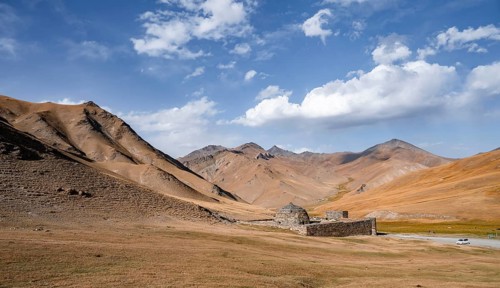 Historic caravanserai Tash Rabat from the 15th century, with yellow hills, Atbashy district in the