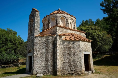 A historic stone church with a blue sky and surrounded by nature, Byzantine Chapel of Agios