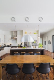 Open-concept dining and kitchen area with antique dining table with black leather and plastic