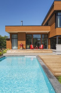 Modern cube style home with stained horizontal wood cladding and in-ground swimming pool, Quebec,