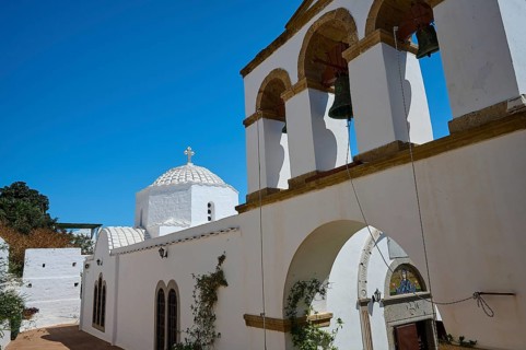 Cross-domed church Diasososuan, White church with a bell tower and several arches, blue sky in the