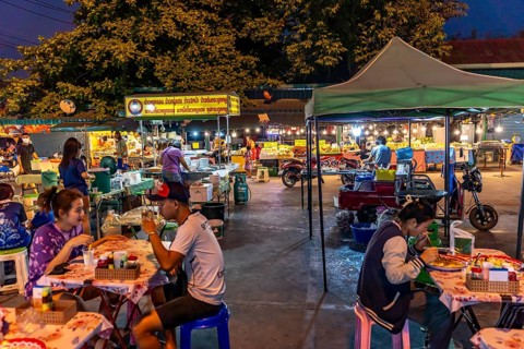 Night market with food stalls and tables at the Chom Thong Food Market in Chom Thong, Thailand,