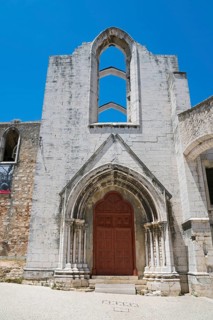 A Gothic church ruin with ornate archways standing out against the clear blue sky, Convento do