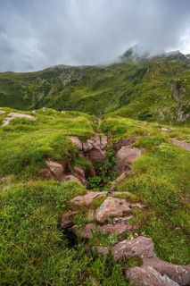 Cloudy mountain landscape with green meadows, Wolayerseehütte, Carnic Alps, Carnic High Trail,
