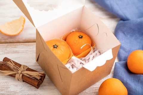 Truffle chocolate tangerine candies on a white wooden background and blue linen textile. Side view,