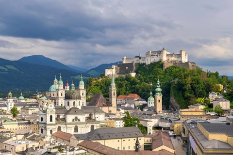 Salzburg's historic city centre with Hohensalzburg Fortress, surrounded by cloudy sky, Salzburg,