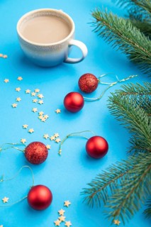 Christmas or New Year composition. Decorations, red balls, fir and spruce branches, cup of coffee,