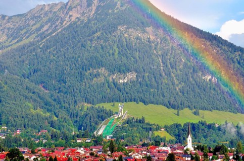 View over Oberstdorf with rainbow, behind it the Schattenberg with Schattenbergschanze, Oberallgäu,