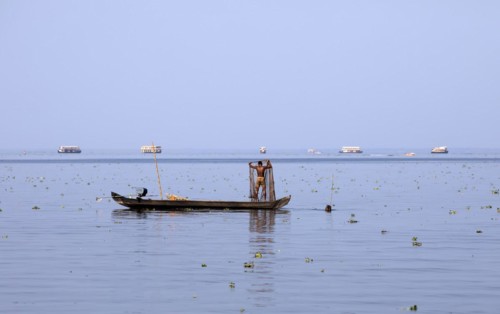 Fisherman on a small boat on the Vembanad Lake, canal system of the backwaters, Kerala, India, Asia