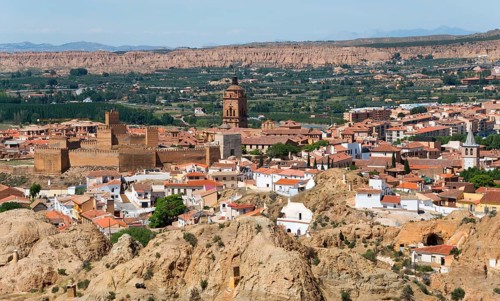 Panoramic view of a city with historical buildings, church and city wall, surrounded by a hilly