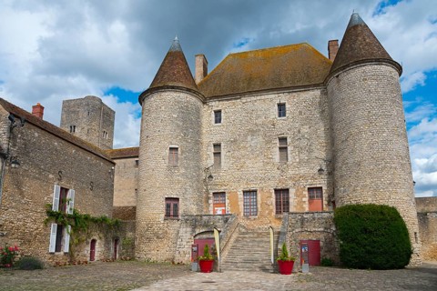 Altes, mittelalterliches Schloss mit markanten Türmen und Steinmauern unter bewölktem Himmel,