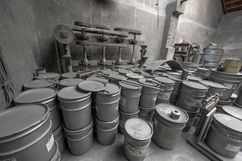Metal barrels covered with zinc dust in the filling room for zinc powder of a metal powder mill,