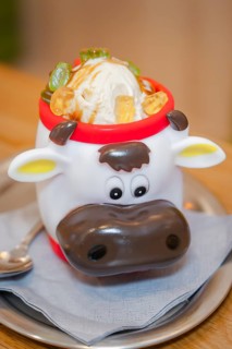 Ice cream in a cute cow cup with pieces of fruit, served on a table, autumn creations, Cafe Kuh,