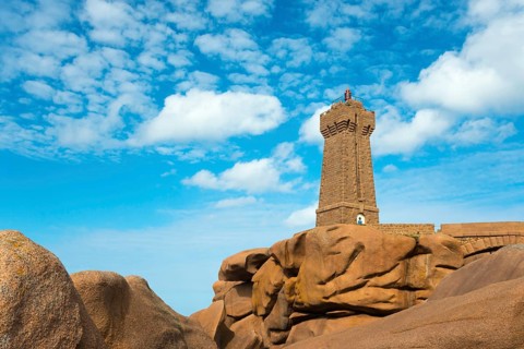 Lighthouse resting majestically on massive rocks under a clear sky, Phare de Men Ruz, Ploumanac'h,