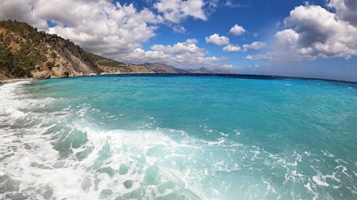 Deep blue sea with a distant coastline and white fleecy clouds in the sky, Kato Lakkos Beach, still