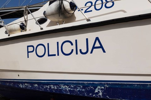 Close-up of Police written in Croatian language on side of maritime police patrol boat, Port of