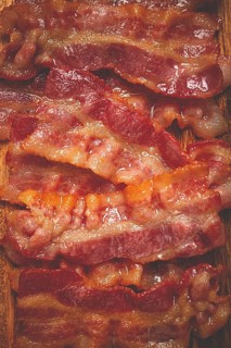Fried bacon on a cutting board, top view, close-up, homemade, breakfast, no people