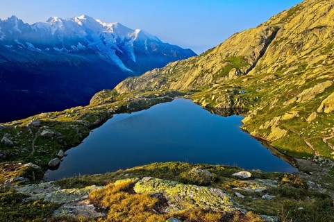 Mountain lake Lacs des Chéserys in the Aiguilles Rouges nature reserve, behind Mont Blanc massif,