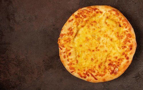 Khachapuri in Megrelian, a traditional Georgian dish, flatbread with cheese, top view, no people