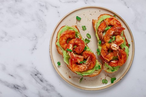 Sandwiches with avocado and caramelized shrimp, micro-greens, breakfast, on a plate, top view,