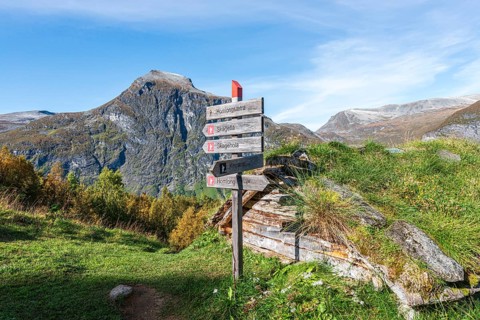 Signpost at Alpe Homlongsætra above the Geirangerfjord, traditional summer farm, Geirangerfjord,