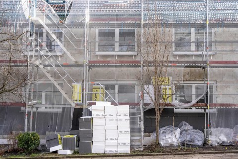 Energetic refurbishment of residential buildings, older apartment building is scaffolded, gets