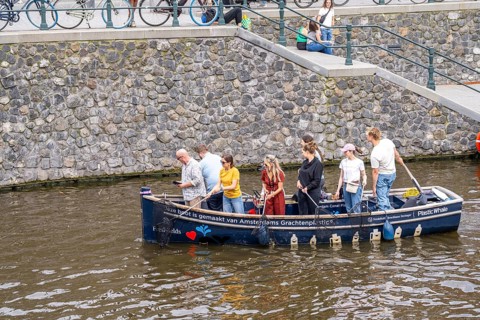 Plastic Whale boat in a canal in Amsterdam, passengers fish plastic waste out of the canals, tour