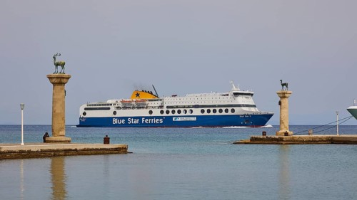 Ferry boat sailing between columns with statues on blue sea, Deer statue, Deer statue, Mandraki